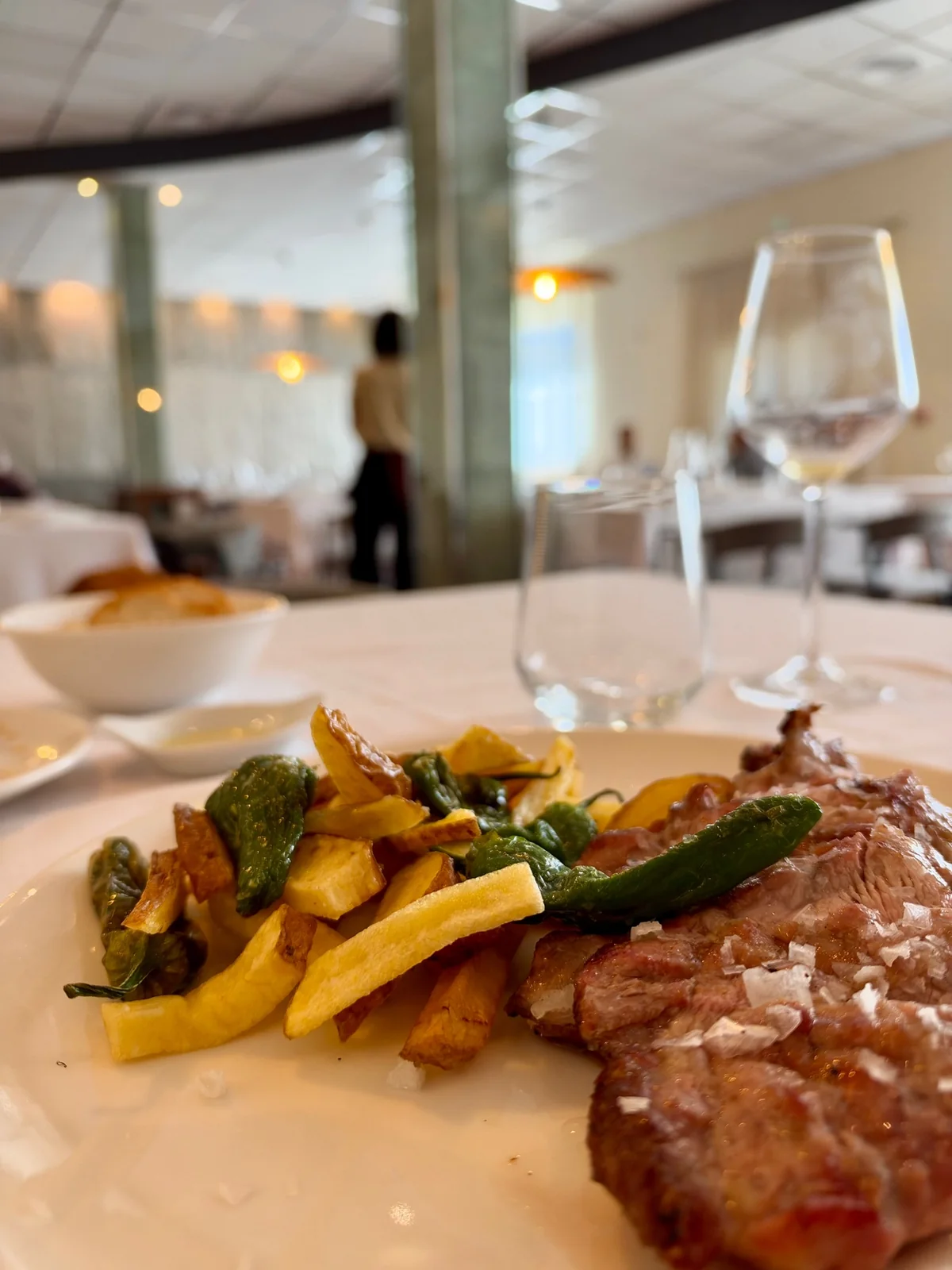 Charcoal-grilled meat with potatoes and peppers, served at Somnium