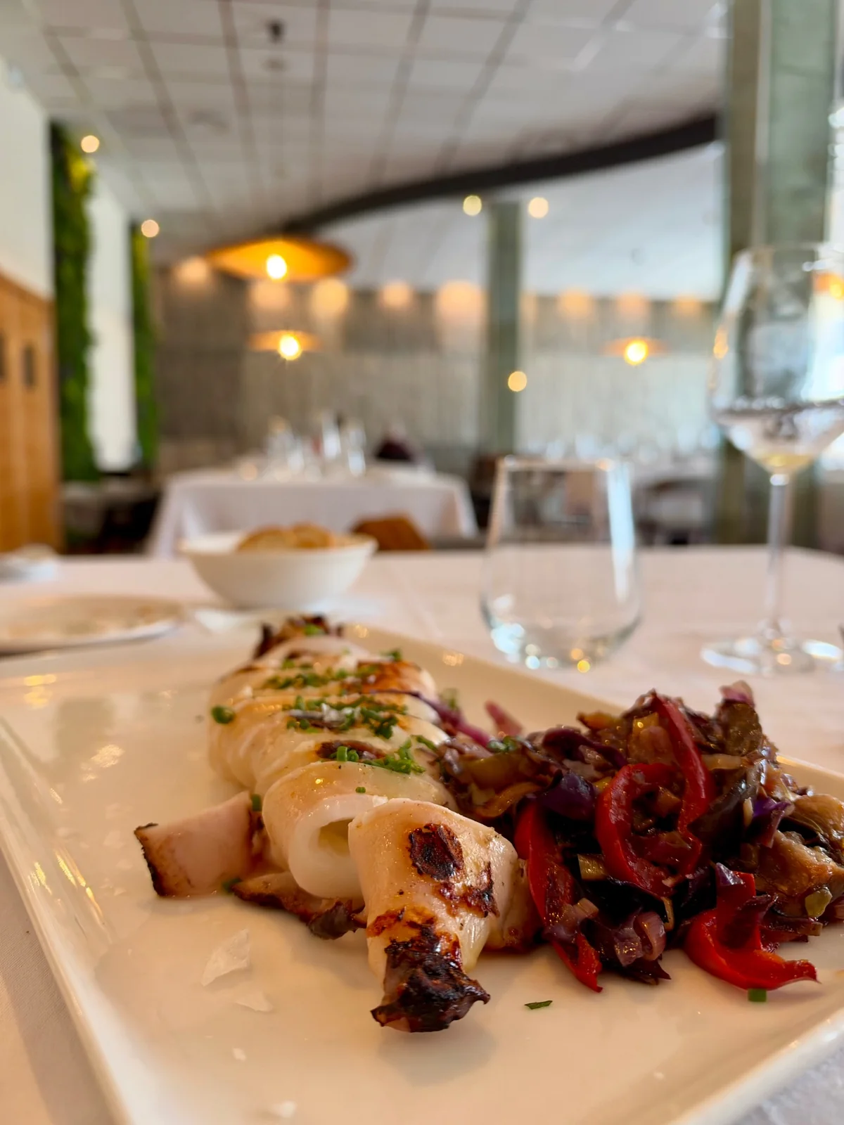 A charcoal-grilled dish served at a table in Somnium’s dining room